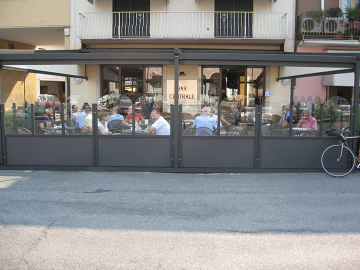 view of people eating at a restaurant with a perogla open and glass dividers